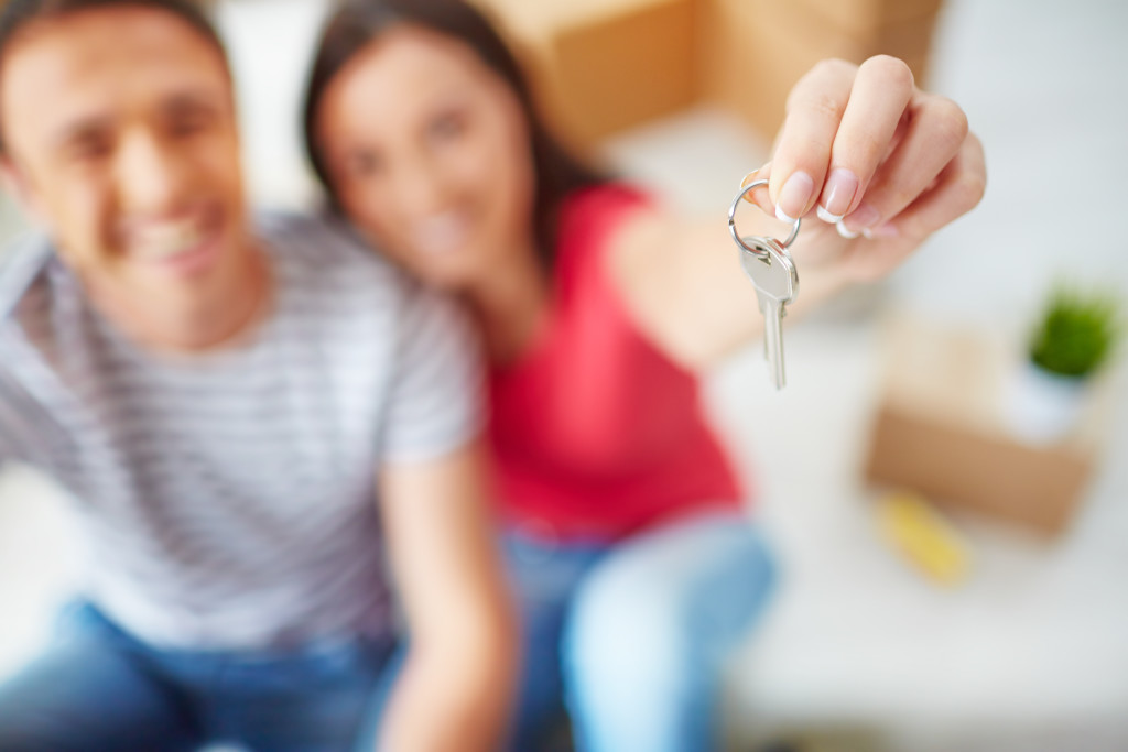 Hand of young woman showing key from new flat